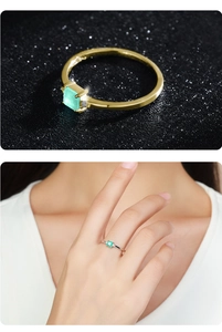 Detail of 925 silver rings with square green stones in gold and silver finishes