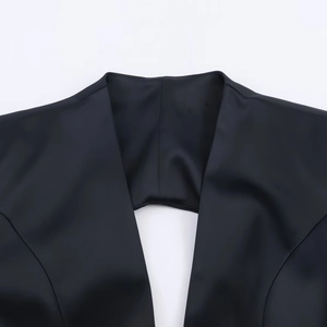 Gros plan détaillé de l'élégante encolure et du tissu noir soyeux de la mini robe