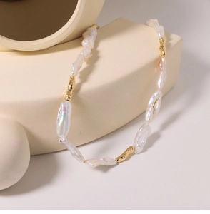 Close-up of baroque freshwater pearl necklace with textured gold-tone metal components