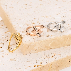 Three butterfly stainless steel rings in gold, rose gold and silver on stone display