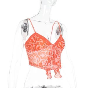 Dettaglio di canotta in chiffon a fiori arancio con pizzo e laccio sullo scollo a V