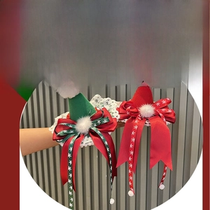 Dettaglio di fermagli per capelli a cappello di Natale rossi e verdi con pizzo e fiocchi