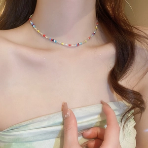 Colorful beaded choker necklace with silver-tone accents worn on model's neck