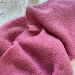 Close-up of soft pink cashmere-like fabric showing rich fuzzy texture and warm material