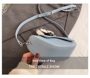 Vue détaillée du sac à main en cuir bleu glacier montrant la poignée en métal argenté