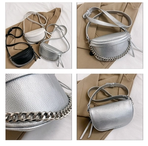 Detail view of lychee texture leather saddle bag with silver chain in black white and silver