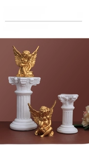 Close-up of golden Cupid angel statues with white Roman column bases for home decor