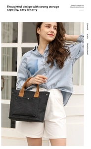 Canvas tote bag detail showing brown handles, front pocket and durable dark grey fabric.