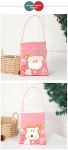 Detailed view of pink Christmas gift bags featuring plush Santa Claus and reindeer designs