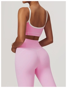 Vue arrière du soutien-gorge de sport rose et du legging avec bordures blanches contrastées