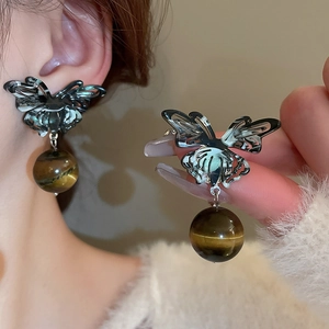 Detailed view of silver butterfly studs with hanging brown tiger eye stone beads
