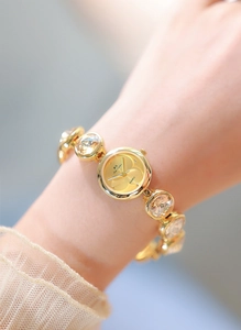 Gros plan sur une montre à quartz dorée pour femme avec bracelet serti de cristaux