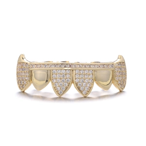 Macro shot of gold hip hop grillz with pavé crystals featuring a sharp canine tooth design