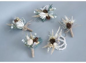 Detailed macro view of handmade dried flower boutonnieres and pine cone wrist corsage