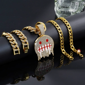 Iced-out emoji pendant with Cuban link chain and bracelet set in gold finish