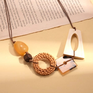 Dettaglio di collana boho con perline in resina, legno e pendenti in rattan intrecciato
