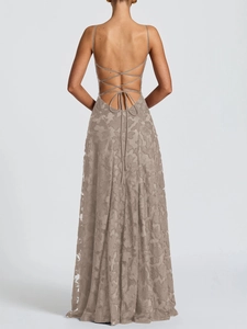 Détail de la texture dentelle et des bretelles croisées au dos d'une robe maxi beige