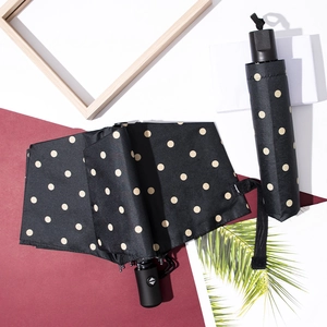 Polka dot black vinyl folding umbrella with UV protection on red and white background