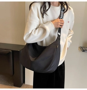 Detail of waterproof nylon dumpling bag with fashion letter strap shown on a model