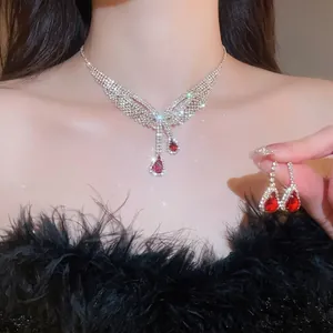 Luxuriöses Schmuckset mit roten Edelsteinen und funkelnden Strasssteinen als Quasten