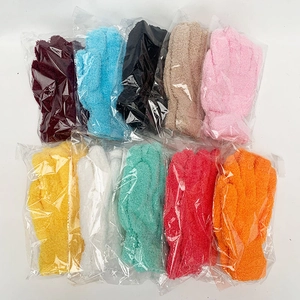Close-up of textured exfoliating bath gloves in ten assorted bright candy colors