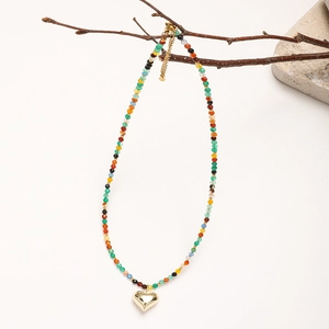 Bohemian natural stone beaded necklace with a golden heart pendant on a branch