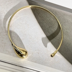 Vue détaillée d'un collier choker doré minimaliste avec goutte d'eau asymétrique