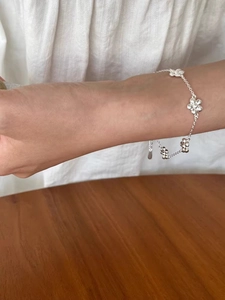 Close-up of a s925 silver flower bracelet worn on wrist with polished petals detail