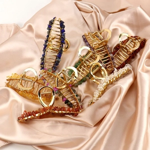 Detailed macro view of large golden alloy hair claws with inlaid natural crystal stones