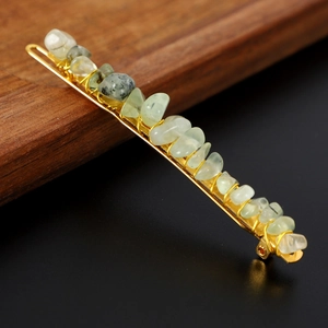 Detail of green and grey natural crystal stones hand-wired on a golden hair clip