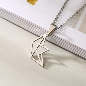 Macro shot of silver origami-style heart necklace on an open book background