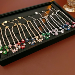 Detailed macro view of zircon flower bracelets in gold and silver finishes with extensions