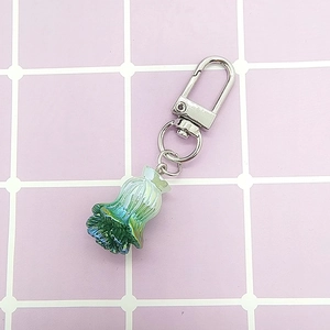 Creative gradient cabbage resin keychain with silver lobster clasp on a grid surface