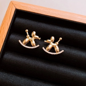 Detail of gold balloon dog earrings with pave crystals on a black velvet display