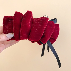 Détail d'une pince à cheveux en velours bordeaux avec paillettes argentées et longs rubans