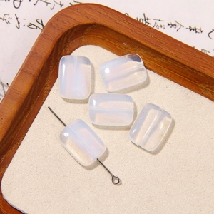 Macro shot of rectangular translucent white glass beads with a metal pin for DIY jewelry
