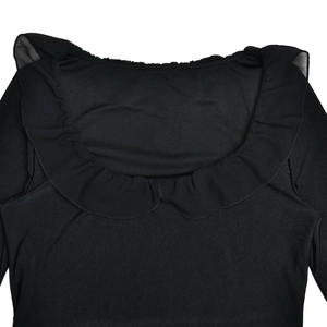 Gros plan sur le décolleté élégant à volants de cette robe noire à manches longues