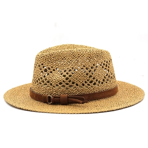 Détail du chapeau de soleil en raphia tissé creux avec ruban marron et boucle dorée