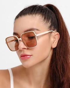 Detail shot of oversized square sunglasses with cream frame and light brown lenses