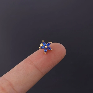 Macro shot of 20G stainless steel stud earring with blue zircon daisy flower design