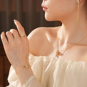 Set di gioielli floreali placcati in oro con petali bianchi e gemme verdi