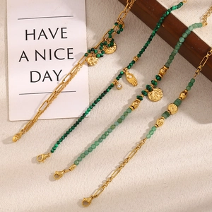 Detail of 18K gold plated Hamsa hand and green natural stone coin charms on link chain