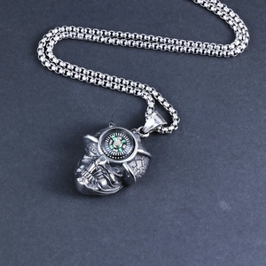 Macro view of vintage silver punk skull pendant with functional green compass dial detail