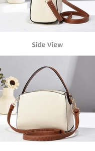 Detail of cream crossbody bag featuring litchi grain texture and gold metal hardware