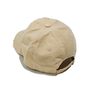 Rear view of distressed beige baseball cap featuring vintage frayed details and adjustable strap