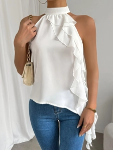 Sleeveless white halter neck top with ruffle detail paired with denim jeans