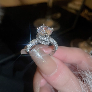 Macro shot of a luxury round zircon ring with side micro-pave diamonds in silver finish