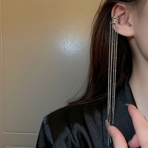 Detail shot of silver irregular C-shape ear cuff with long elegant chain tassels
