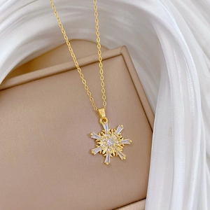 Elegant gold titanium snowflake necklace with sparkling crystals on silk background