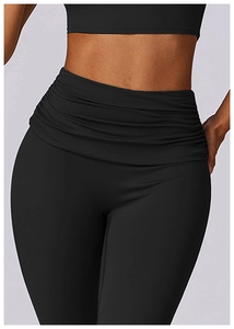 Detail of high-waisted yoga pants featuring horizontal waist pleats in matte black